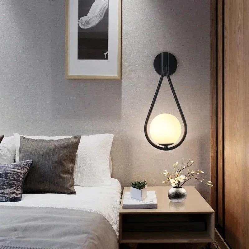 DARBE Nordic Brass Wall Light, frosted glass globe design, wall-mounted beside bed in bedroom.